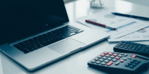 Espacio de trabajo con laptop y documentos financieros de un ERP.